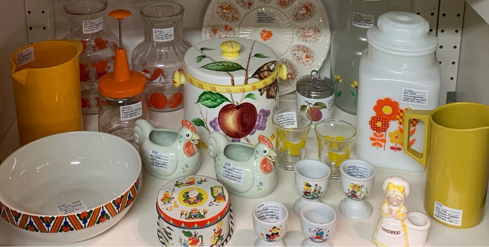 Collection of ceramic items including jars, bowls, and decorative pieces on a shelf.