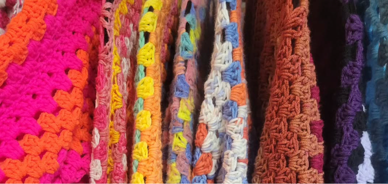 Close-up of colorful crocheted fabric with various patterns and colors.